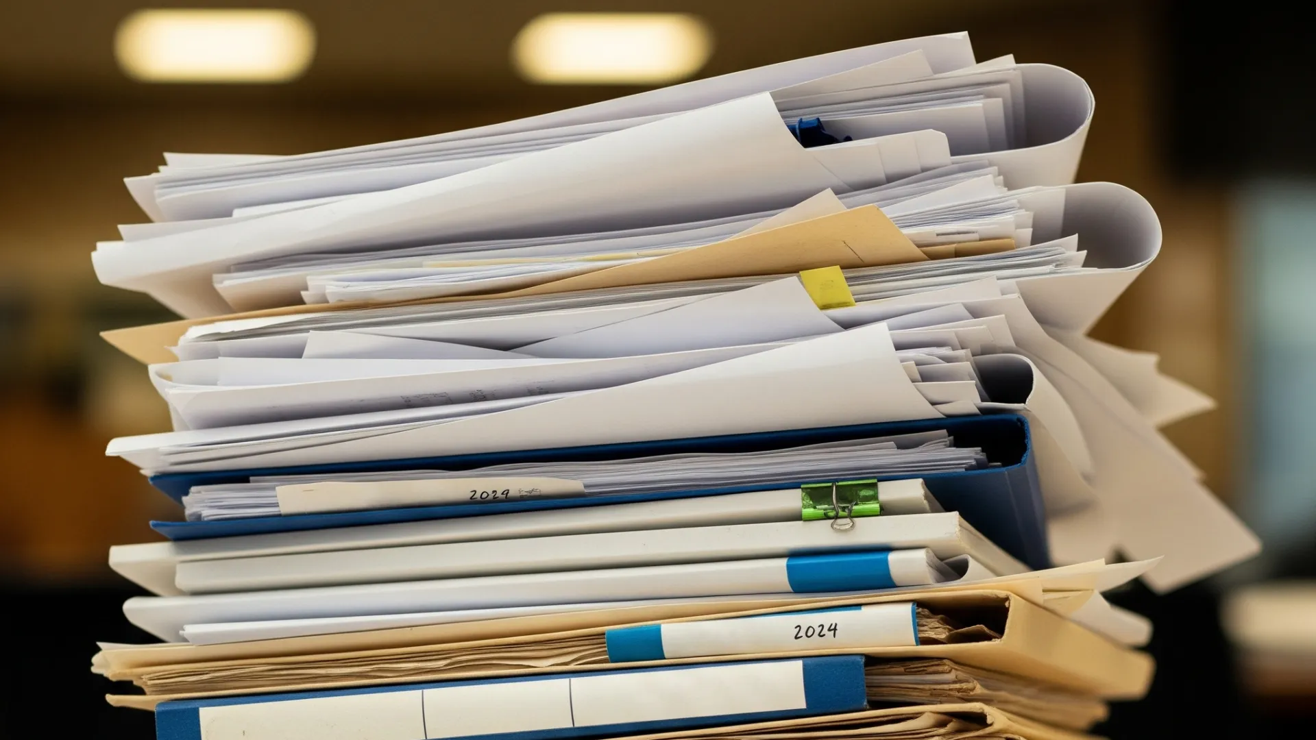 Stos dokumentów i teczek symbolizujący zmiany w prawie budowlanym 2026 i konieczność szybkiego działania w kwestii pozwoleń