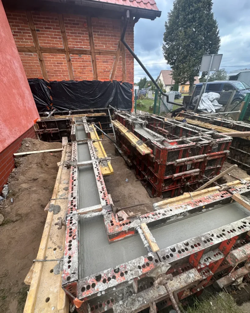 Szalunki zalewane betonem na budowie pochylni dla osób z niepełnosprawnością