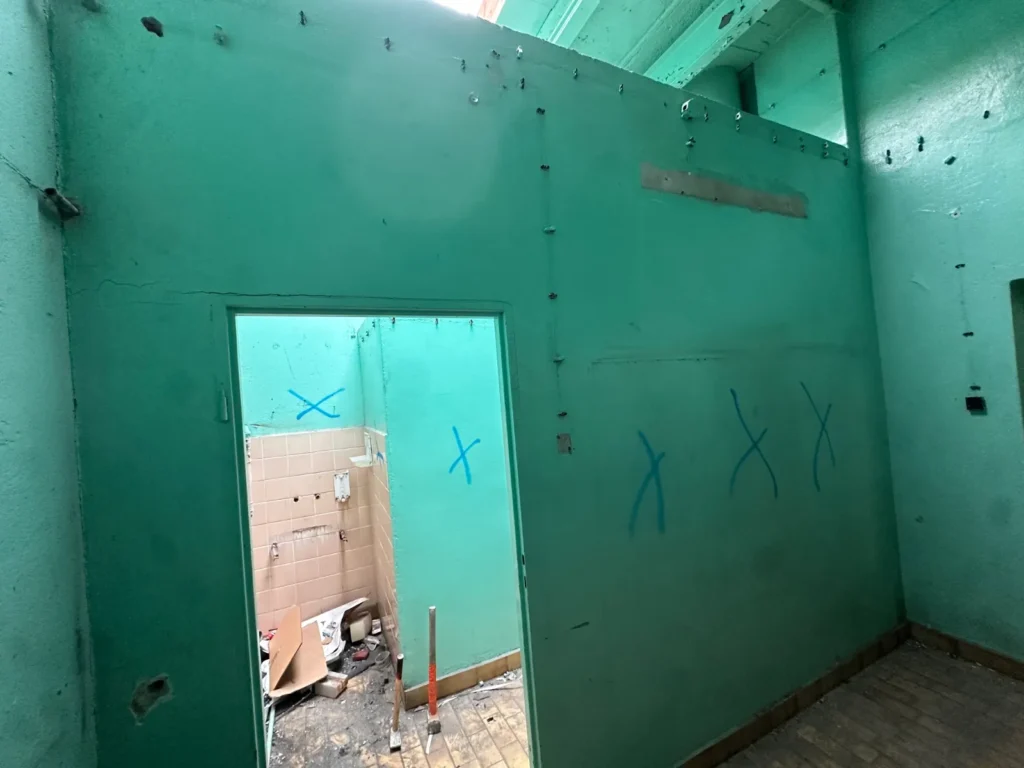 Ciasne pomieszczenia starego magazynu w Szczecinie widoczne na pierwszym planie ściany działowe, które są zgodnie z projektem do rozbiórki.